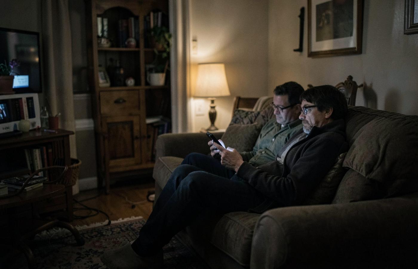 Parents sitting in a living room in the evening